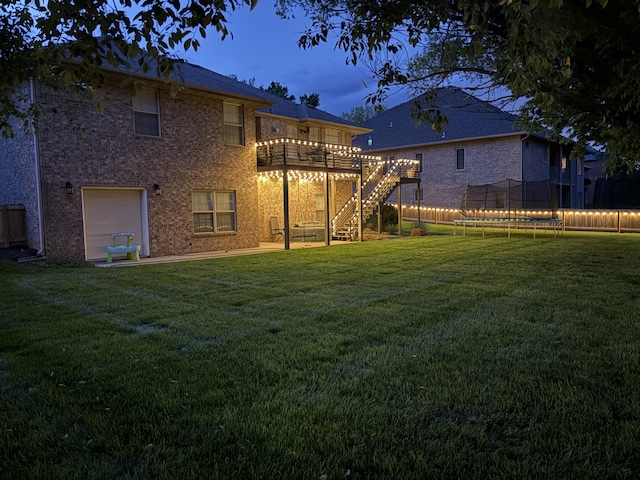 604 N Cascades Dr, Nixa, MO 65714 - rear view of property with a trampoline, stairs, a deck, a garage, and brick siding