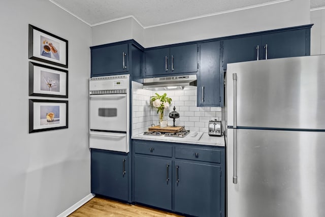 801 N Myrtle St, Pierce City, MO 65723 - kitchen featuring white appliances, a warming drawer, under cabinet range hood, blue cabinets, and crown molding