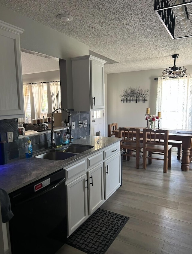3943 W Kay Pointe Blvd, Springfield, MO 65802 - kitchen featuring dishwasher, a sink, a textured ceiling, backsplash, and wood finished floors