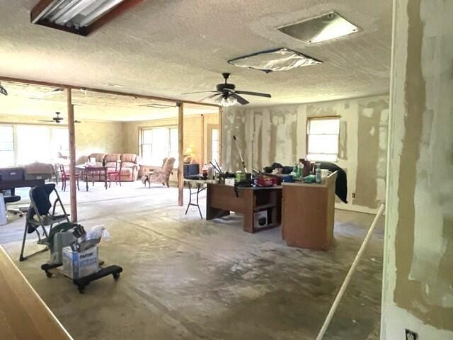 10694 Red Spring Rd, Mountain Grove, MO 65711 - miscellaneous room with a textured ceiling, unfinished concrete flooring, and ceiling fan
