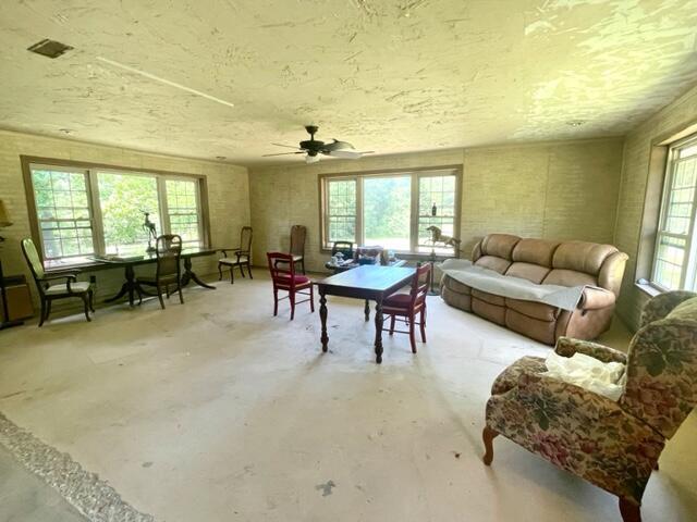 10694 Red Spring Rd, Mountain Grove, MO 65711 - living room with concrete floors, healthy amount of natural light, a textured ceiling, and ceiling fan