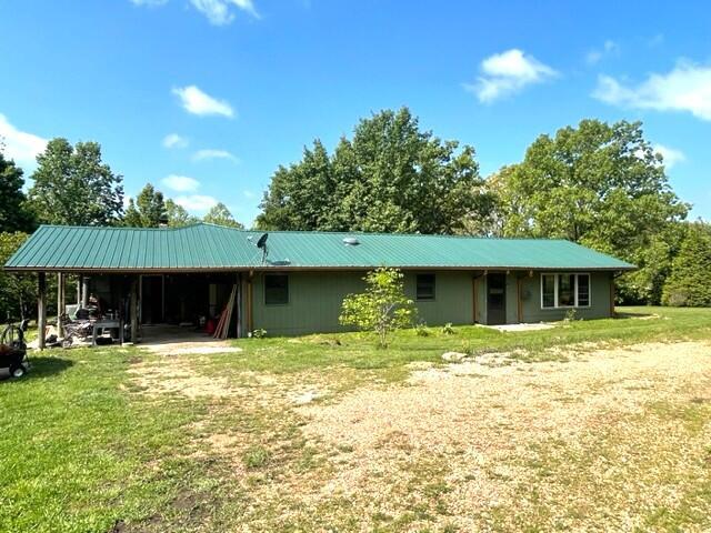 10694 Red Spring Rd, Mountain Grove, MO 65711 - back of house featuring a carport, a lawn, and metal roof