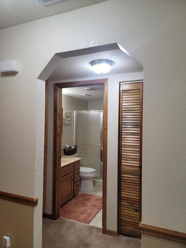 150 Sunken Forest Dr Unit 235, Forsyth, MO 65653 - full bathroom featuring toilet, a stall shower, vanity, a textured ceiling, and a textured wall
