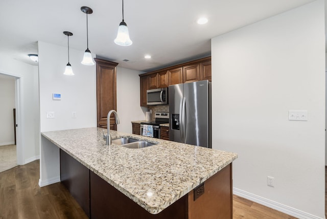 131 Lake Beach Ln, Hollister, MO 65672 - kitchen with appliances with stainless steel finishes, a sink, baseboards, light stone countertops, and dark wood-style flooring