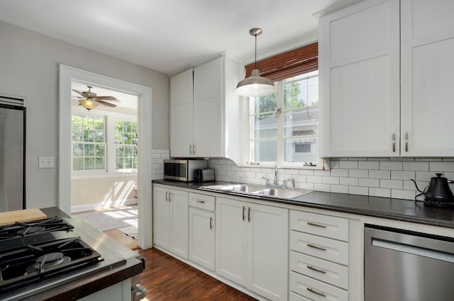 1501 E Walnut St, Springfield, MO 65802 - kitchen with stainless steel appliances, dark countertops, a sink, tasteful backsplash, and healthy amount of natural light