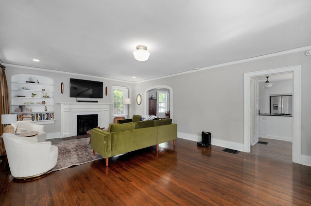 1501 E Walnut St, Springfield, MO 65802 - living room featuring arched walkways, ornamental molding, wood finished floors, a fireplace, and baseboards