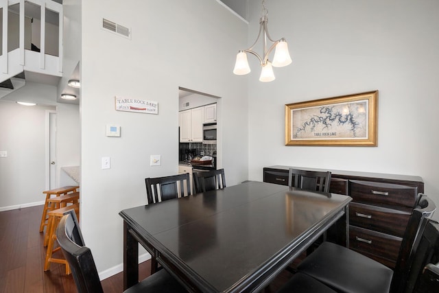 10 Treehouse Ln Unit 11, Branson, MO 65616 - dining area featuring a chandelier, dark wood-style floors, a towering ceiling, and baseboards