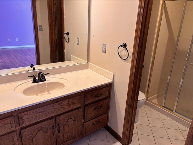 bathroom with toilet, tile patterned flooring, vanity, and a stall shower