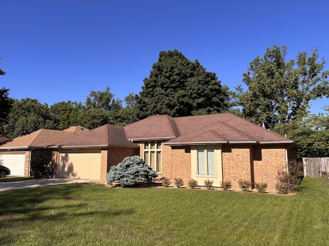 view of front of property featuring a garage, a front lawn, and brick siding