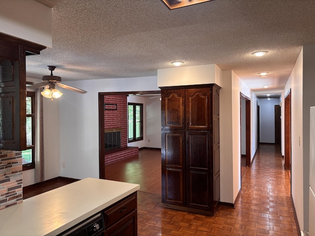 kitchen with ceiling fan, dark brown cabinets, baseboards, and a textured ceiling