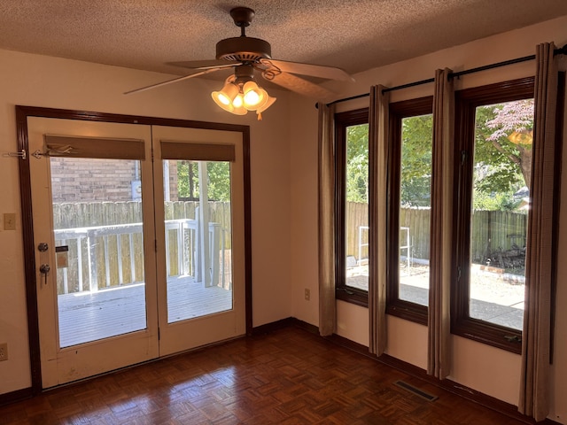 doorway to outside with a textured ceiling, a ceiling fan, and baseboards