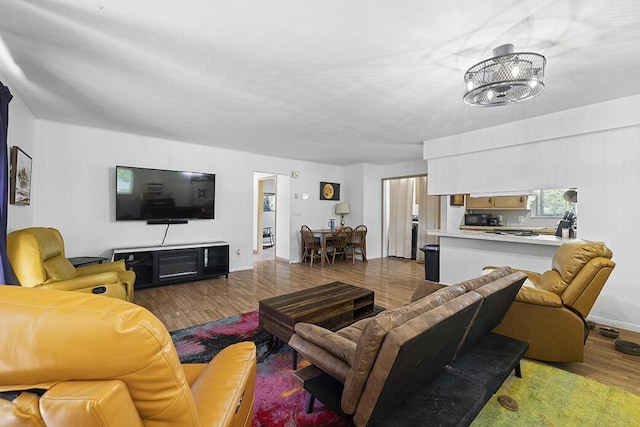 103 W Mockingbird Ln, Crane, MO 65633 - living room featuring wood finished floors, a chandelier, and baseboards