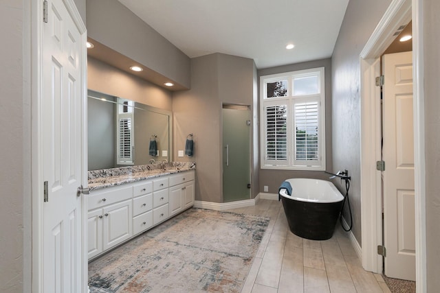 2539 S Forrest Heights Ave, Springfield, MO 65809 - bathroom with double vanity, a shower stall, a freestanding tub, recessed lighting, and baseboards