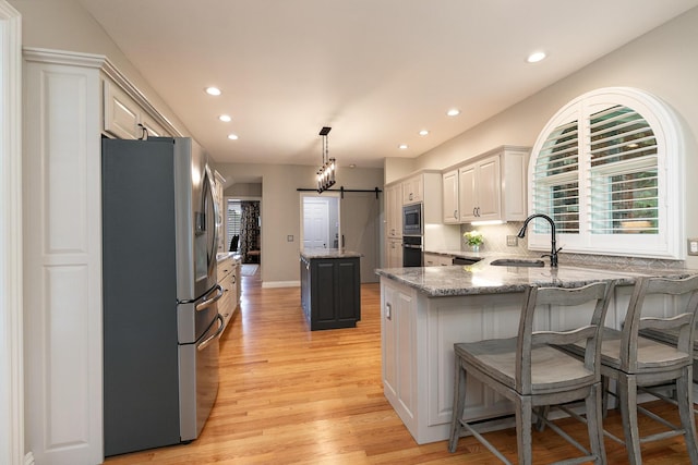 2539 S Forrest Heights Ave, Springfield, MO 65809 - kitchen featuring stainless steel appliances, a sink, a barn door, a kitchen island, and a peninsula
