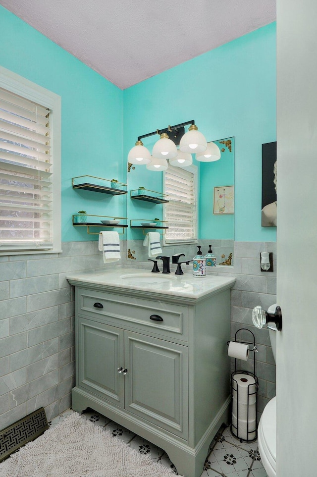 1511 E University St, Springfield, MO 65804 - half bathroom with tile walls, tile patterned flooring, vanity, toilet, and wainscoting