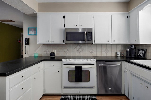1511 E University St, Springfield, MO 65804 - kitchen with appliances with stainless steel finishes, a peninsula, and dark countertops