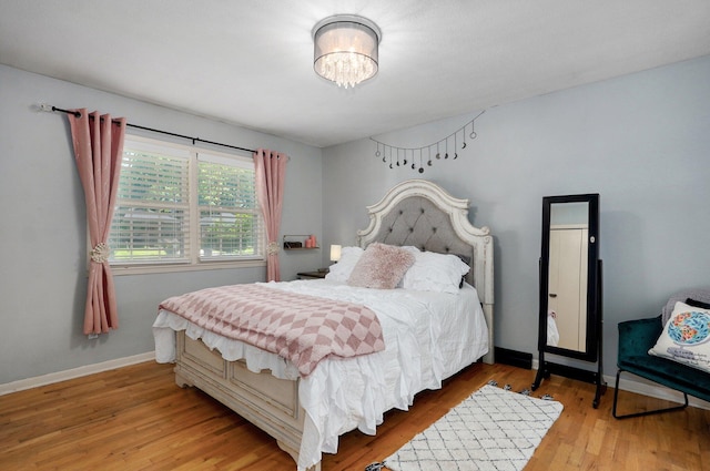 1511 E University St, Springfield, MO 65804 - bedroom with wood finished floors, a chandelier, and baseboards