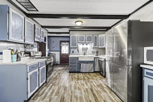 5680 N Farm Rd Unit 215, Strafford, MO 65757 - kitchen featuring appliances with stainless steel finishes, a sink, light wood finished floors, light countertops, and glass insert cabinets