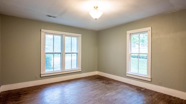 222 Poplar St, Thayer, MO 65791 - empty room featuring dark wood-style flooring, healthy amount of natural light, and baseboards