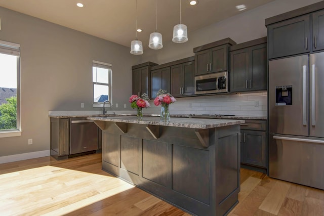 622 N Rockingham Ave, Nixa, MO 65714 - kitchen featuring stainless steel appliances, a center island, a breakfast bar area, decorative backsplash, and recessed lighting