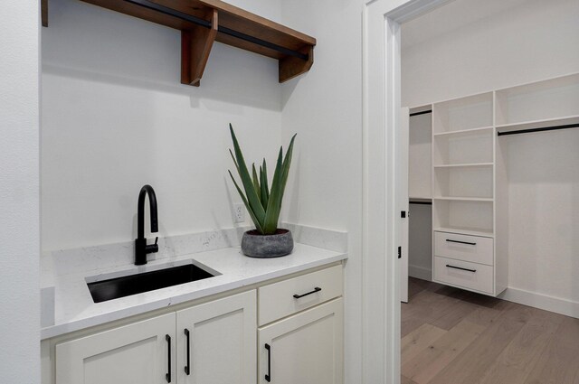 1744 E Cobblestone Dr, Ozark, MO 65721 - bar area featuring a sink, light wood-style floors, and baseboards