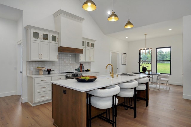 1744 E Cobblestone Dr, Ozark, MO 65721 - kitchen with wood finished floors, decorative backsplash, a kitchen breakfast bar, light countertops, and electric range