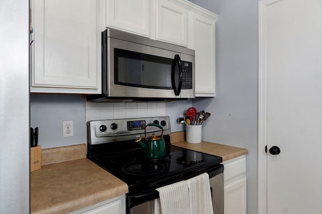 1141 N Hilton Ave, Springfield, MO 65803 - kitchen featuring electric stove, stainless steel microwave, decorative backsplash, white cabinets, and light countertops