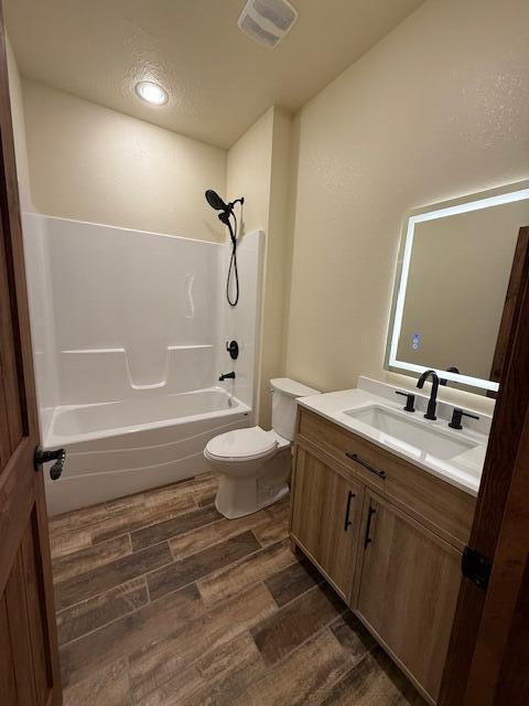 429 E S St, Mountain Grove, MO 65711 - full bathroom featuring wood finished floors, toilet, vanity, and bathing tub / shower combination