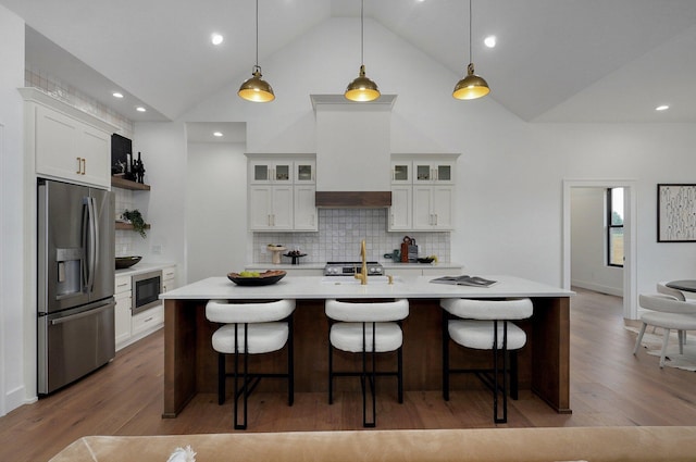 1702 E Cobblestone Dr, Ozark, MO 65721 - kitchen featuring stainless steel appliances, light countertops, wood finished floors, open shelves, and backsplash