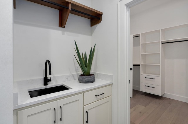 1702 E Cobblestone Dr, Ozark, MO 65721 - bar area featuring a sink, light wood-style floors, and baseboards