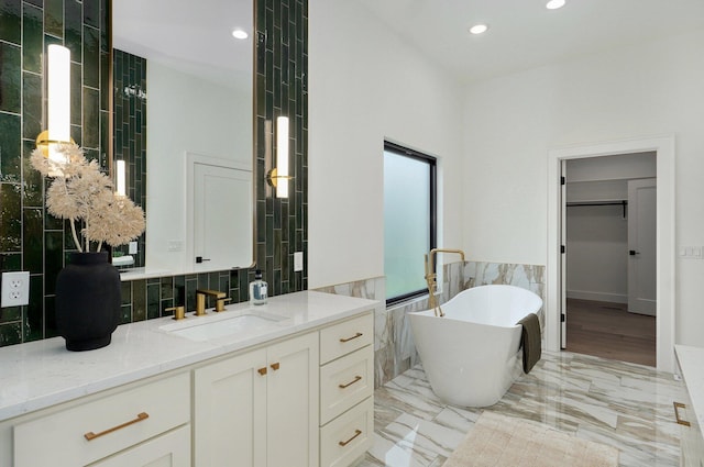 1702 E Cobblestone Dr, Ozark, MO 65721 - bathroom with a freestanding tub, vanity, recessed lighting, tile walls, and a spacious closet