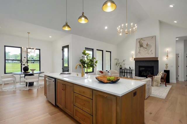 1702 E Cobblestone Dr, Ozark, MO 65721 - kitchen featuring a chandelier, stainless steel dishwasher, a sink, brown cabinetry, and light countertops