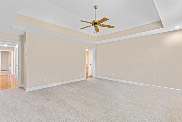 8205 Quail Ridge Ct, Nixa, MO 65714 - spare room with attic access, a ceiling fan, light colored carpet, a tray ceiling, and baseboards