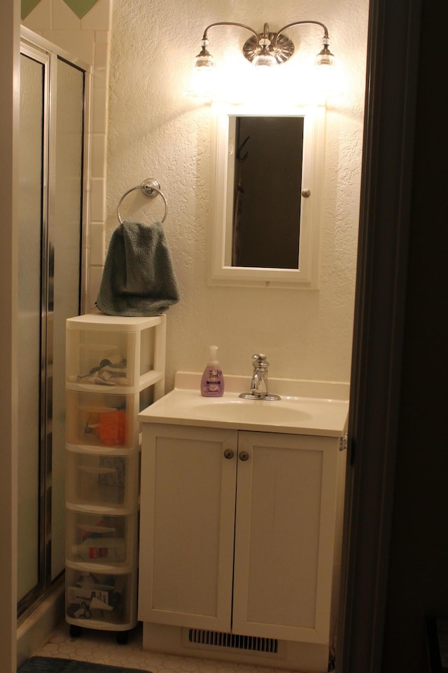 1012 E 3rd St, Monett, MO 65708 - bathroom featuring a textured wall, vanity, and a stall shower