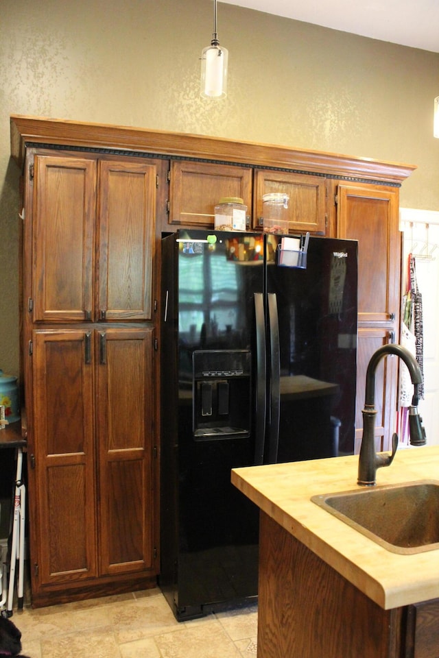 1012 E 3rd St, Monett, MO 65708 - kitchen featuring black refrigerator with ice dispenser, a sink, butcher block countertops, a textured wall, and brown cabinets