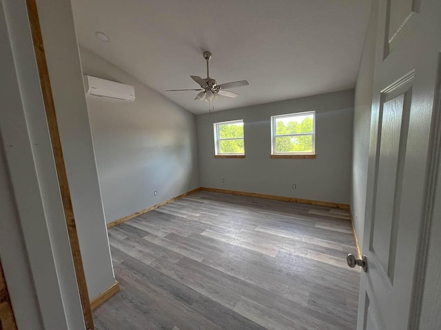 000 Reid Dr, Theodosia, MO 65761 - spare room with an AC wall unit, ceiling fan, vaulted ceiling, wood finished floors, and baseboards