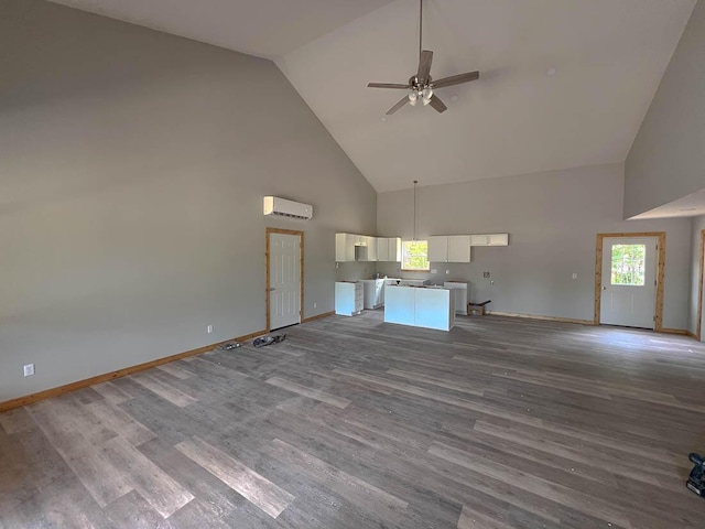 000 Reid Dr, Theodosia, MO 65761 - unfurnished living room featuring high vaulted ceiling, ceiling fan, a wall mounted AC, baseboards, and wood finished floors
