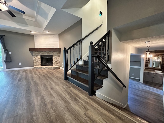 3223 W Primrose St, Springfield, MO 65807 - staircase with wood finished floors, ceiling fan, baseboards, and a fireplace