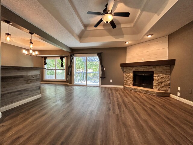 3223 W Primrose St, Springfield, MO 65807 - unfurnished living room with a tray ceiling, baseboards, dark wood-style floors, and a textured ceiling