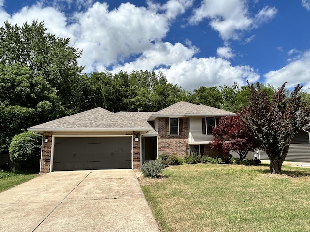 3223 W Primrose St, Springfield, MO 65807 - tri-level home with driveway, a garage, a front yard, and brick siding