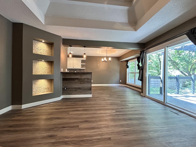 3223 W Primrose St, Springfield, MO 65807 - unfurnished living room featuring baseboards, a chandelier, dark wood finished floors, and a textured ceiling