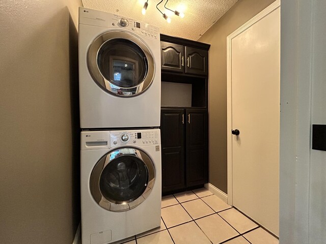 3223 W Primrose St, Springfield, MO 65807 - laundry room featuring cabinet space, estacked washer and dryer, light tile patterned floors, and a textured ceiling