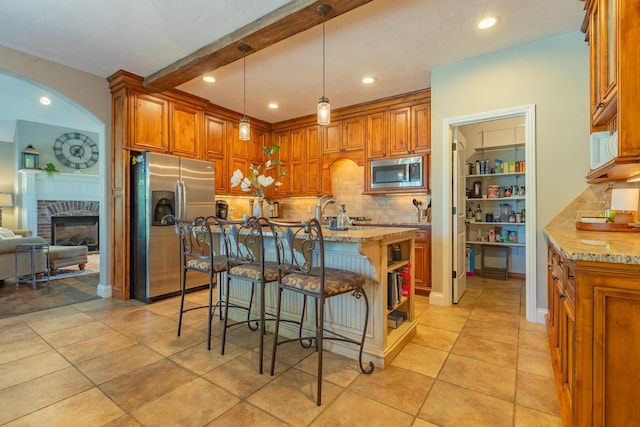 853 E Grafton Dr, Nixa, MO 65714 - kitchen featuring appliances with stainless steel finishes, tasteful backsplash, brown cabinets, light stone counters, and recessed lighting