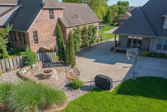 853 E Grafton Dr, Nixa, MO 65714 - view of property exterior featuring an outdoor fire pit, board and batten siding, brick siding, roof with shingles, and a patio