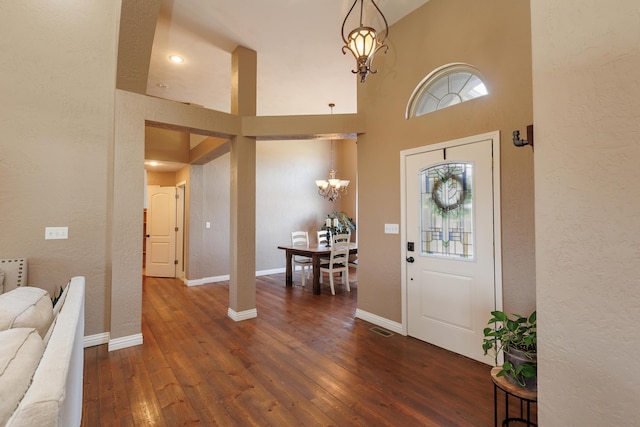 1415 Woodland Rd, Marshfield, MO 65706 - entrance foyer featuring a chandelier, dark wood-style flooring, a towering ceiling, a textured wall, and baseboards