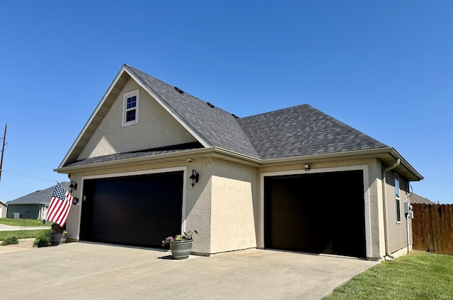 1415 Woodland Rd, Marshfield, MO 65706 - view of home's exterior featuring stucco siding, roof with shingles, and driveway