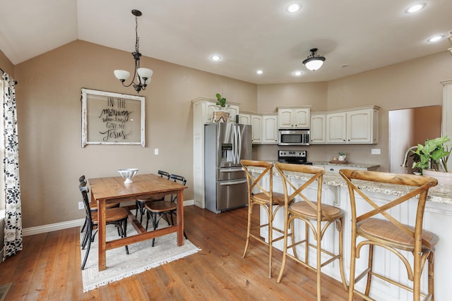 1415 Woodland Rd, Marshfield, MO 65706 - kitchen featuring appliances with stainless steel finishes, light wood-style floors, decorative light fixtures, baseboards, and a kitchen bar