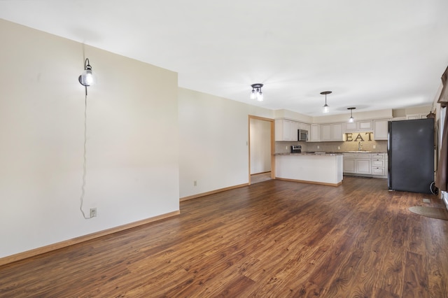 300 S High Ave, Ash Grove, MO 65604 - unfurnished living room featuring a sink, dark wood-style floors, and baseboards