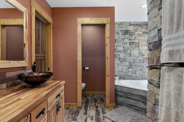 8403 Lawrence Unit 1040, La Russell, MO 64848 - bathroom with vanity, toilet, wood finished floors, and a bath