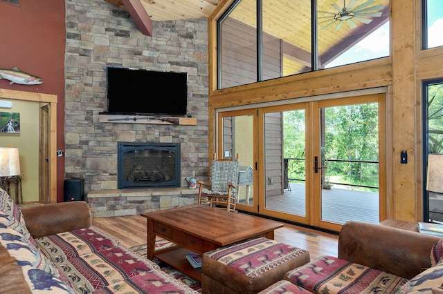 8403 Lawrence Unit 1040, La Russell, MO 64848 - living area featuring french doors, a stone fireplace, wooden ceiling with exposed beams, wood finished floors, and high vaulted ceiling